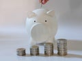 hand with coin over piggy bank. money savings, cash deposit concept Royalty Free Stock Photo