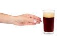 Hand with cold glass of dark beer or kvass with foam isolated on white background. Royalty Free Stock Photo