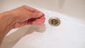 A hand collecting dark long female fallen hair in a washing bowl, hair loss after washing and brushing hair, androgenic Royalty Free Stock Photo