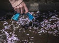 Hand collects a dirty mask to throw away for cleaning in the park Royalty Free Stock Photo