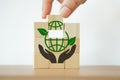 Hand complete green globe icon on cube ,CSR, eco green sustainable living, zero waste, plastic free, earth day, world environment