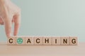 hand completed coaching word on wooden cube blocks with green smiling face instead of O, including copy space