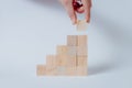 Hand completing business growth conceptual on wooden cubes