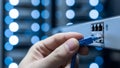 Hand connecting blue network cable to server in data center rack with blinking lights Royalty Free Stock Photo