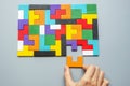 Hand connecting geometric shape block with colorful wood puzzle pieces. logical thinking, business logic, Conundrum, decision, Royalty Free Stock Photo