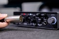 Hand connecting a robust silver XLR cable to a professional black audio interface, showcasing vital studio equipment setup for Royalty Free Stock Photo