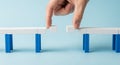 Hand connecting two bridge segments made of building blocks Royalty Free Stock Photo