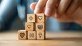 Hand Constructing a Tower with Wooden Blocks Featuring Medical Icons Like Heart and Brain