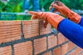 Hand of construction worker laying down brick wall one by one us Royalty Free Stock Photo