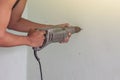 Hand of construction workers and handymen work using an electric drill to drill holes to the wall. Royalty Free Stock Photo