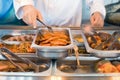 Hand of cook takes nippers fried meat