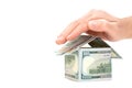 Hand covering a house made from dollar bills Royalty Free Stock Photo