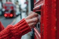 Close-up of a Hand Posting Letter in Red Mailbox on City Street. Daily Life and Communication Concept. Street Royalty Free Stock Photo