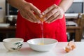 Hand cracking egg into a bowl for cooking