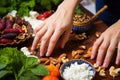 hand cracking pepper over salad of figs, walnuts, and goat cheese