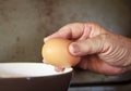 Hand Cracking and pouring Egg into a Bowl.