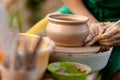 Hand craft making pottery on wheel. Female hands mold ceramic plate from clay pot Royalty Free Stock Photo