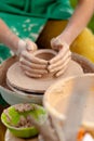 Hand craft making pottery on wheel. Female hands mold ceramic plate from clay pot Royalty Free Stock Photo