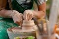 Hand craft making pottery on wheel. Female hands mold ceramic plate from clay pot Royalty Free Stock Photo