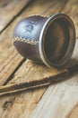 Hand Crafted Artisanal Yerba Mate Tea Leather Calabash Gourd with Straw on Weathered Plank Wood Background Royalty Free Stock Photo