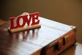 Hand crafted wood endearment that reads 'Love' set on man's briefcase