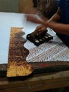 Hand of craftman / artist make a printed batik using stamp