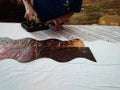 Hand of craftman / artist make a printed batik using stamp