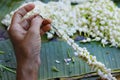 Hand creating garland of jasmine flower