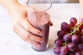 hand creating a pattern of flaxseed on a thick grape smoothie