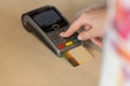 Hand with credit card swipe through terminal for payment in cafe. Royalty Free Stock Photo