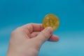 In the hand of cryptocurrency bitcoin Golden, on blue background Royalty Free Stock Photo