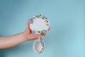 Hand and cup on blue background. Man holding White cup with pain Royalty Free Stock Photo