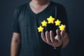 hand of customer or client holding the stars to complete five stars with copy space.Service rating,giving a five star rating. Royalty Free Stock Photo