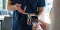 Hand of customer paying with contactless credit card with NFC technology. Bartender with a credit card reader machine at bar Royalty Free Stock Photo