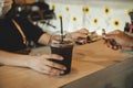 Hand customer paying with credit card for buying ice black coffee on counter in modern cafe coffee shop Royalty Free Stock Photo