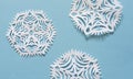 Hand cut diy white paper snowflakes on the blue background