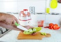 Hand cut with a knife the green pepper on a cutting board. Juicing fresh vegetables. Fresh Juice