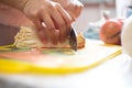 A hand cutting a bunch of enoki mushroom or flammulina filiformis on a chopping board