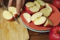 The hand cuts the half of the apple on the cutting board Royalty Free Stock Photo