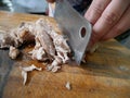 Hand cutting pork shop with knife on wooden