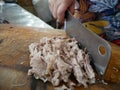 Hand cutting pork shop with knife on wooden