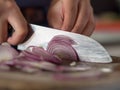 Hand cutting red onions on cutting board. Royalty Free Stock Photo