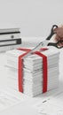 Hand Cutting Red Ribbon on Stack of Papers Royalty Free Stock Photo