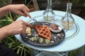 Hand cutting waffle with kiwi and ice cream on black plate. Waffle with honey. Dessert sweetness. Royalty Free Stock Photo