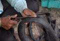 cycle mechanic cutting a part of a tyre tube