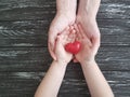 Hand dad and child heart red on black wooden