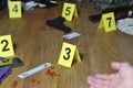 Hand of dead victim surrounded by evidence markers and objects on floor of residential apartment. Crime scene investigation and Royalty Free Stock Photo