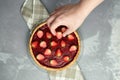 Hand decorating summer strawberry pie with fresh berries halves Royalty Free Stock Photo