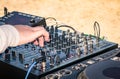 Hand of a deejay playing music on professional mixer