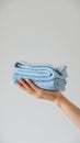 Hand delicately holds blue microfiber cloth, emphasizing cleanliness on white background Royalty Free Stock Photo